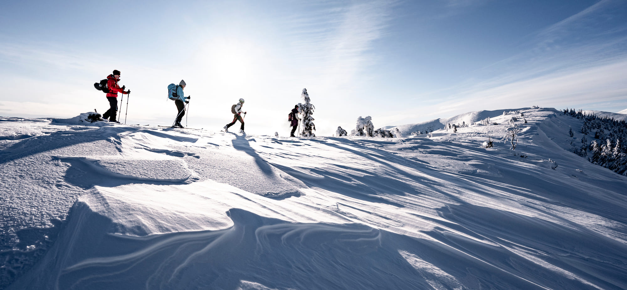 Skiers walking on the edge of a snowy mountain